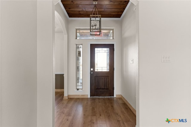 foyer with light wood-type flooring, crown molding, and wood ceiling