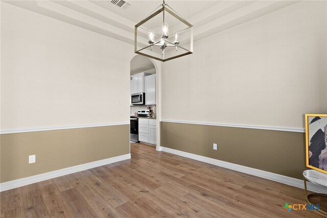 kitchen featuring white cabinets, light hardwood / wood-style floors, decorative light fixtures, and an inviting chandelier