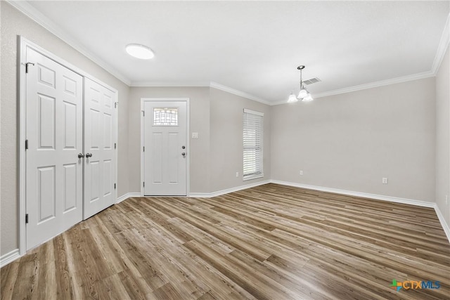 3301 Bonham Ave, Temple, TX 76502 - foyer with wood finished floors, a chandelier, crown molding, and baseboards
