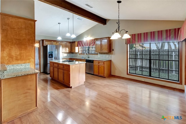 kitchen featuring pendant lighting, light hardwood / wood-style flooring, vaulted ceiling with beams, appliances with stainless steel finishes, and a notable chandelier