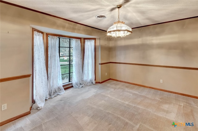 spare room with a textured ceiling, crown molding, light carpet, and an inviting chandelier