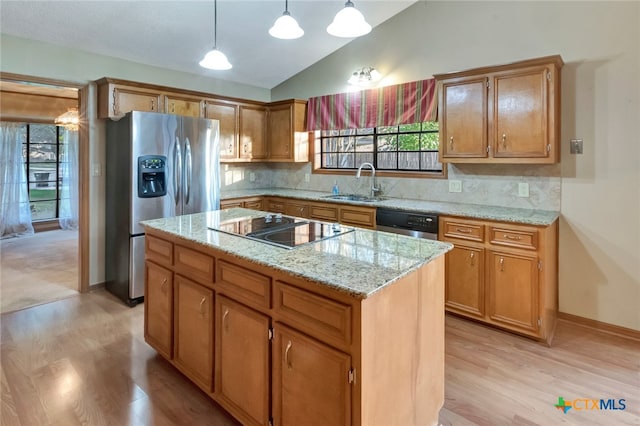 kitchen with a center island, sink, vaulted ceiling, light hardwood / wood-style floors, and stainless steel appliances