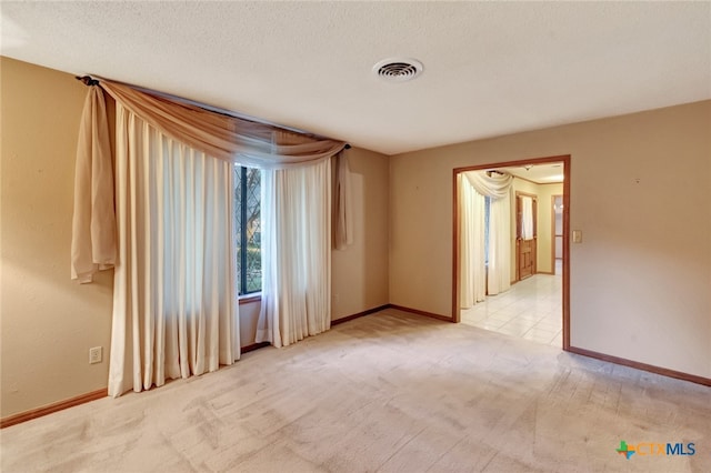 carpeted spare room featuring a textured ceiling