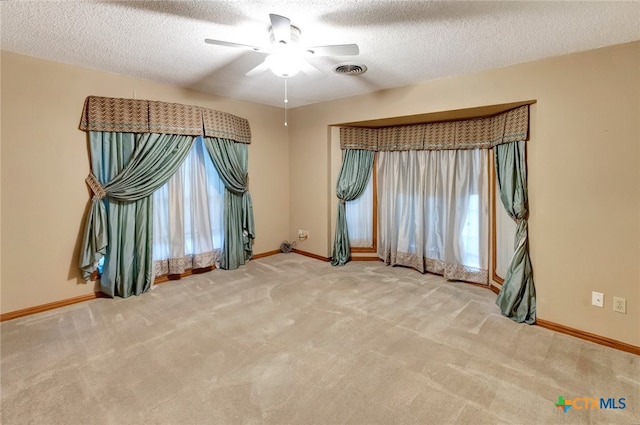 unfurnished room featuring carpet flooring, ceiling fan, and a textured ceiling