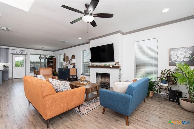 3810 Twilight Dr, Temple, TX 76502 - living room with ornamental molding, a ceiling fan, light wood-style flooring, a large fireplace, and plenty of natural light