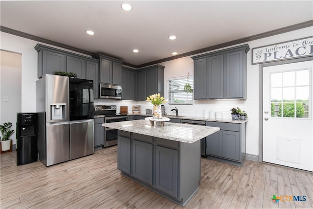 3810 Twilight Dr, Temple, TX 76502 - kitchen featuring appliances with stainless steel finishes, ornamental molding, light stone countertops, backsplash, and light wood-style floors