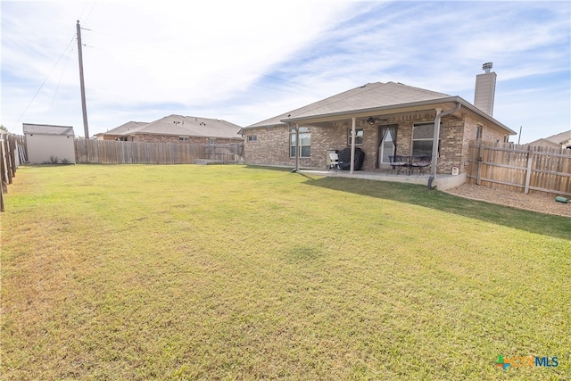 view of yard featuring ceiling fan and a patio