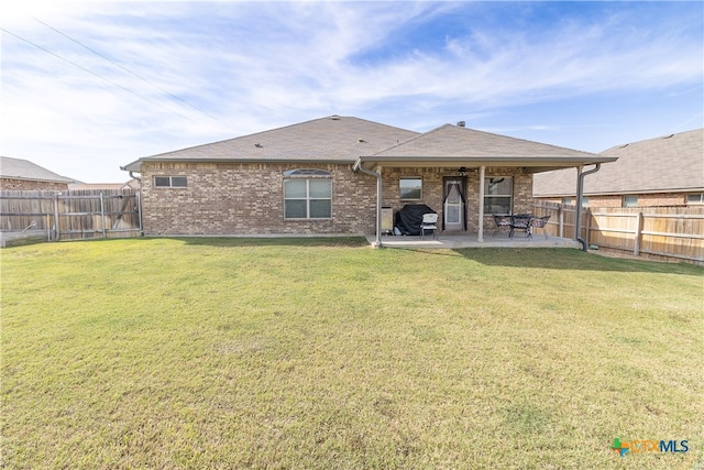 rear view of property with a lawn and a patio