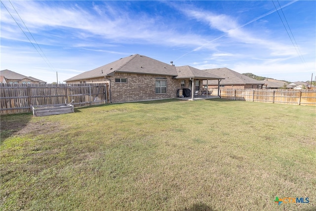 back of property with a lawn and a patio