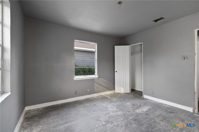 unfurnished bedroom with a closet and hardwood / wood-style flooring