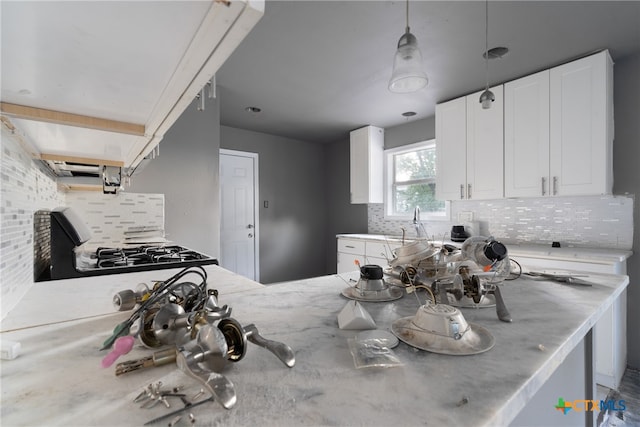 kitchen featuring white cabinets, black range, sink, and tasteful backsplash