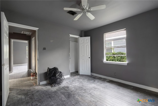 unfurnished bedroom featuring ceiling fan and dark hardwood / wood-style flooring