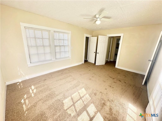 unfurnished bedroom with a ceiling fan, baseboards, carpet floors, and a textured ceiling