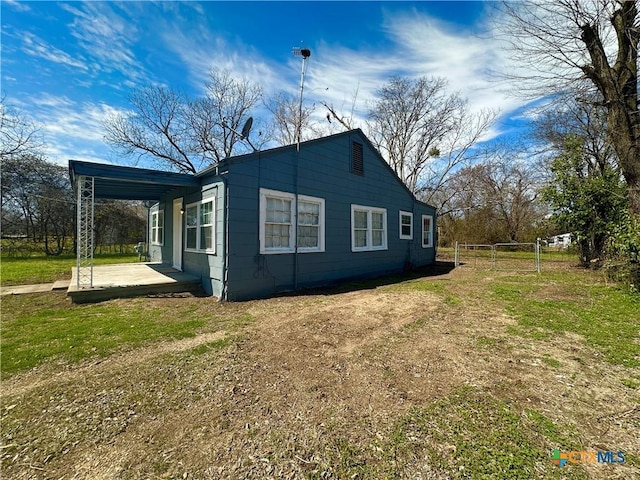 view of side of home with an attached carport and driveway