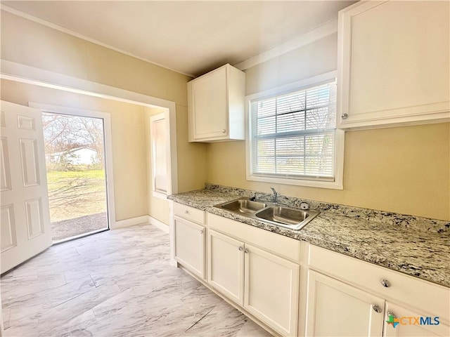 kitchen featuring marble finish floor, baseboards, and a sink