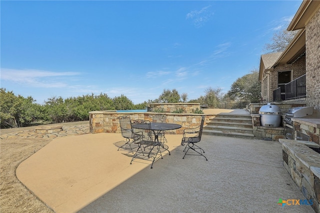 view of patio featuring grilling area, exterior kitchen, and outdoor dining space