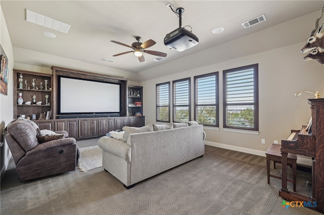 home theater with dark carpet, visible vents, and baseboards