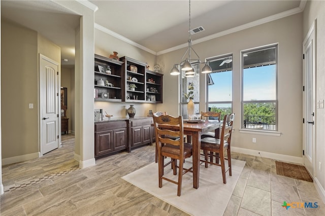 dining room featuring baseboards, visible vents, and crown molding