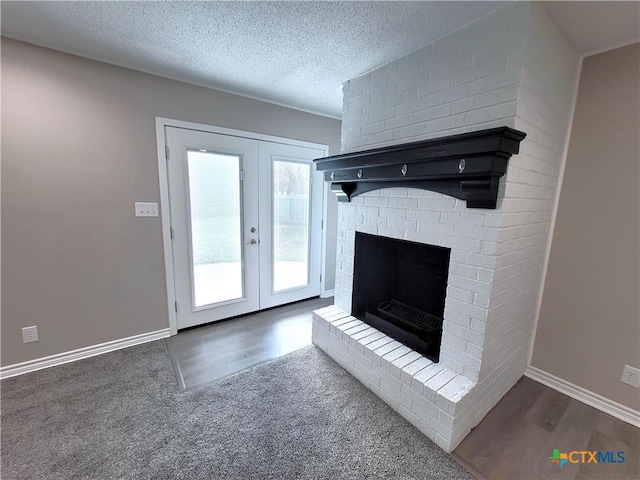 interior space with french doors, a brick fireplace, and a textured ceiling