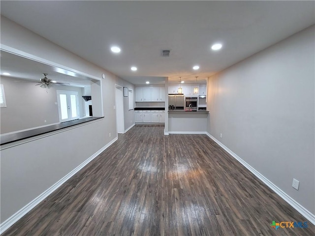 unfurnished living room featuring ceiling fan and dark hardwood / wood-style floors