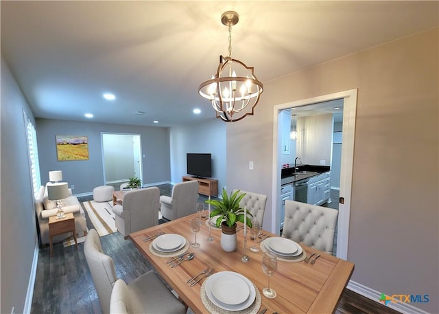 dining area featuring an inviting chandelier, dark hardwood / wood-style flooring, and sink