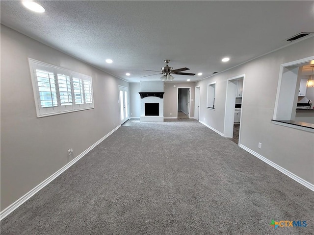 unfurnished living room featuring ceiling fan, carpet, and a textured ceiling