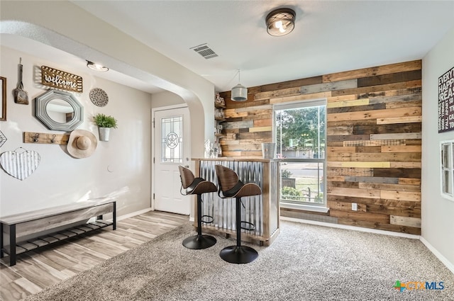 bar with light colored carpet and wood walls