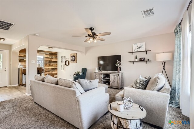 living room with wooden walls and ceiling fan