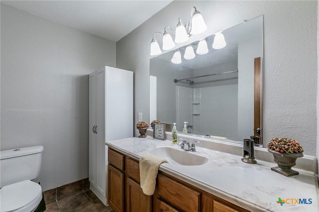 bathroom with tile patterned floors, walk in shower, vanity, and toilet