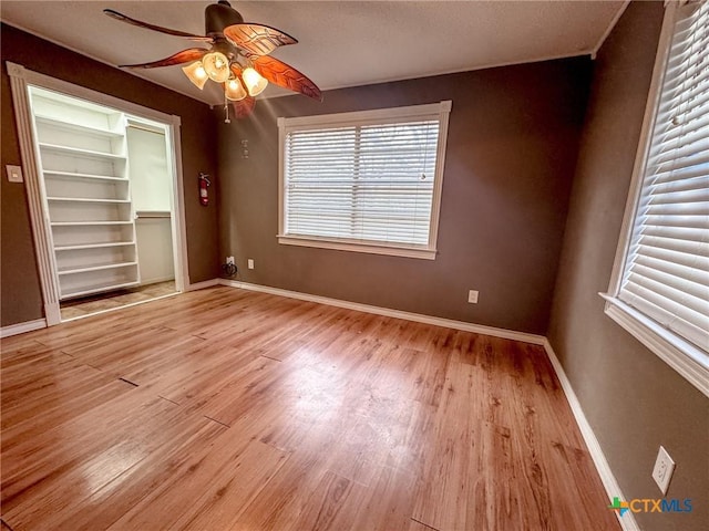 empty room with ceiling fan and light hardwood / wood-style floors