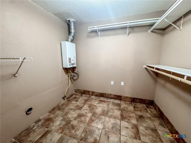 washroom featuring a textured ceiling and water heater