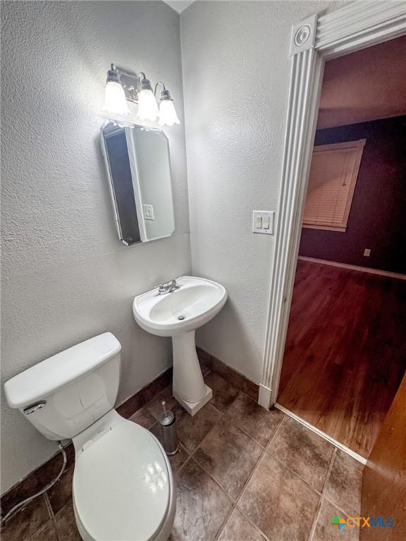 bathroom with hardwood / wood-style floors and toilet