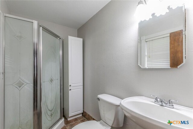 bathroom featuring tile patterned floors, toilet, an enclosed shower, and sink