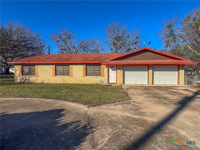 ranch-style house featuring a front lawn and a garage