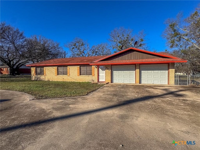 ranch-style house featuring a front yard and a garage