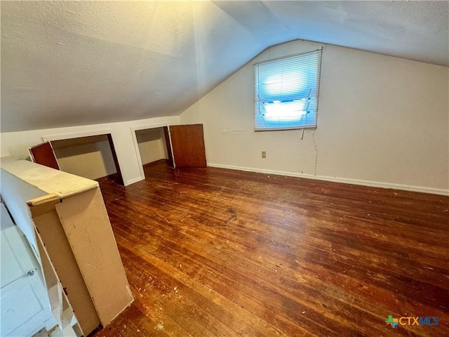 702 E Anaqua Ave, Victoria, TX 77901 - additional living space featuring wood-type flooring, lofted ceiling, and a textured ceiling