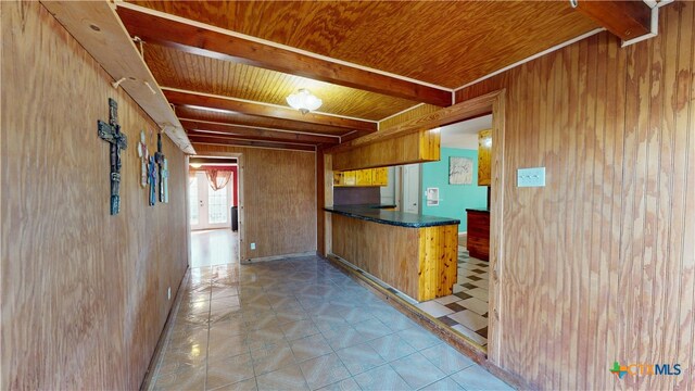 702 E Anaqua Ave, Victoria, TX 77901 - kitchen featuring wood walls, a wood ceiling with exposed beams, dark countertops, a peninsula, and brown cabinetry