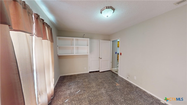 702 E Anaqua Ave, Victoria, TX 77901 - unfurnished bedroom featuring baseboards and a textured ceiling