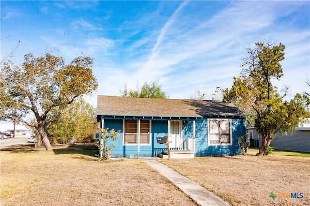 bungalow-style home featuring covered porch and a front yard