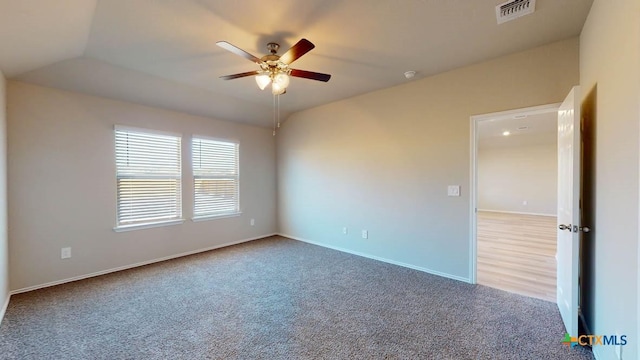 empty room featuring lofted ceiling, ceiling fan, and carpet