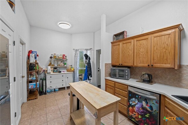 699 Irish Ln, Killeen, TX 76539 - kitchen with dishwasher, light countertops, tasteful backsplash, light tile patterned floors, and brown cabinets