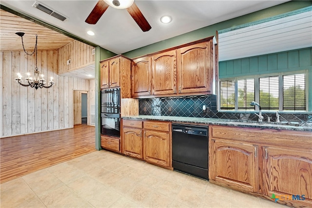 kitchen featuring decorative backsplash, black appliances, wooden walls, light hardwood / wood-style flooring, and decorative light fixtures