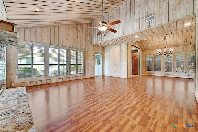 unfurnished living room featuring ceiling fan with notable chandelier, wood ceiling, wood walls, hardwood / wood-style flooring, and high vaulted ceiling