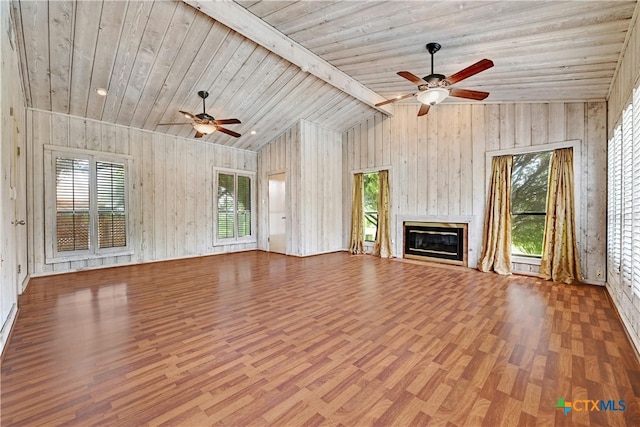 unfurnished living room featuring lofted ceiling with beams, light hardwood / wood-style floors, wood walls, and wooden ceiling