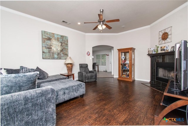 602 Dusty Trl, Belton, TX 76513 - living room with arched walkways, wood finished floors, ceiling fan, ornamental molding, and a tiled fireplace