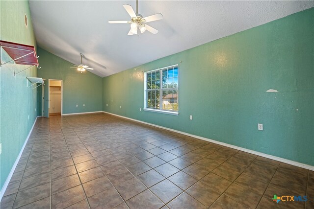 empty room featuring lofted ceiling, ceiling fan, and tile patterned floors