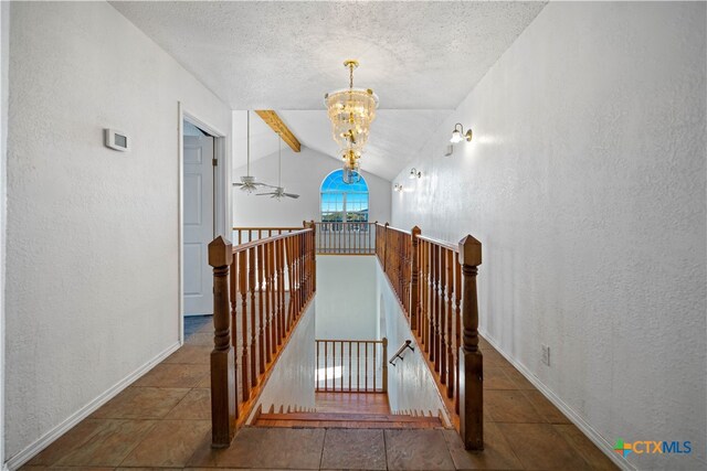 stairs featuring a textured ceiling, ceiling fan with notable chandelier, tile patterned flooring, and vaulted ceiling with beams