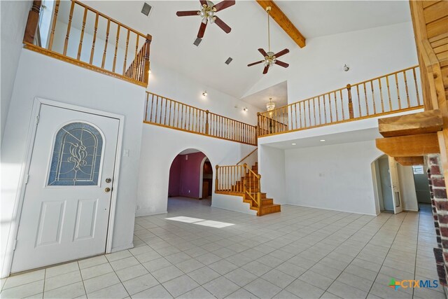 entryway with high vaulted ceiling, beamed ceiling, light tile patterned floors, and ceiling fan