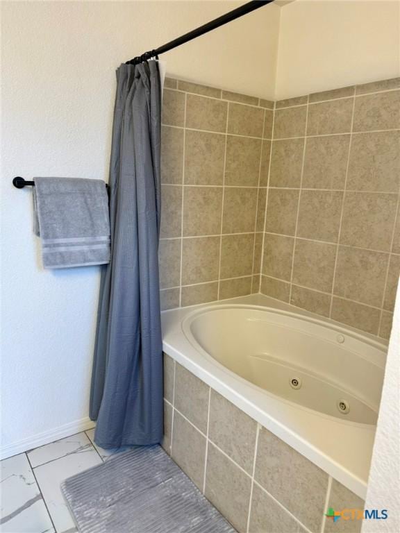 full bath with a combined bath / shower with jetted tub and baseboards