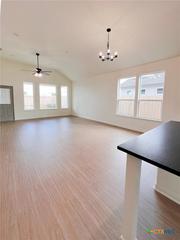 116 Raindance Ct, Victoria, TX 77904 - unfurnished living room featuring vaulted ceiling, light wood-type flooring, a chandelier, and a ceiling fan